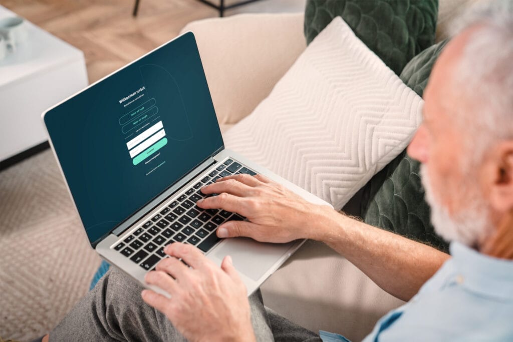 Älterer Mann sitzt entspannt auf dem Sofa und registriert sich auf der Dating-Plattform DuoLivo – Online-Dating ab 50 in der Schweiz.