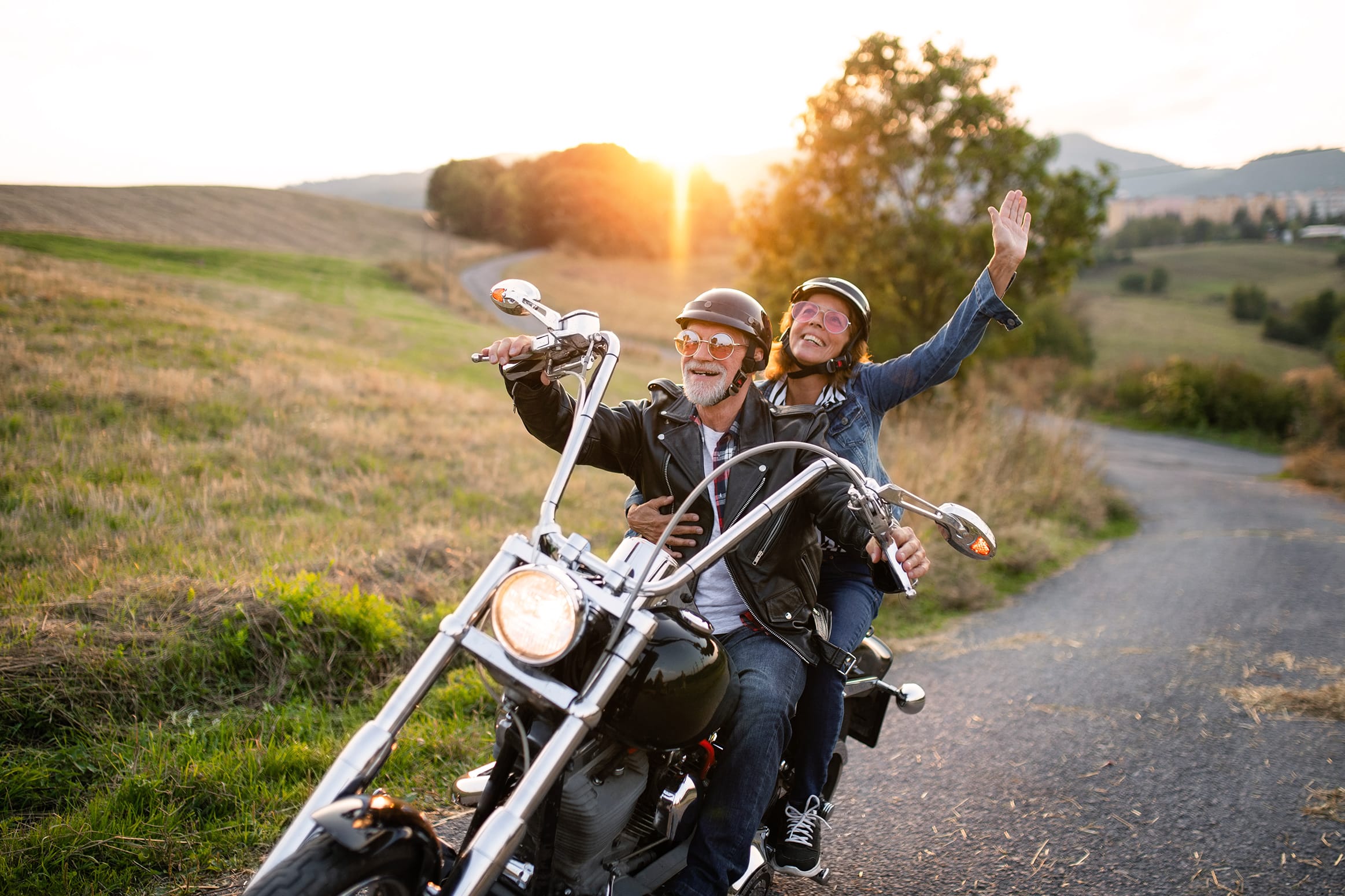 Fröhliches älteres Paar fährt gemeinsam Motorrad durch die Natur und geniesst das Leben – echte Lebensfreude mit DuoLivo, Online-Dating ab 50.