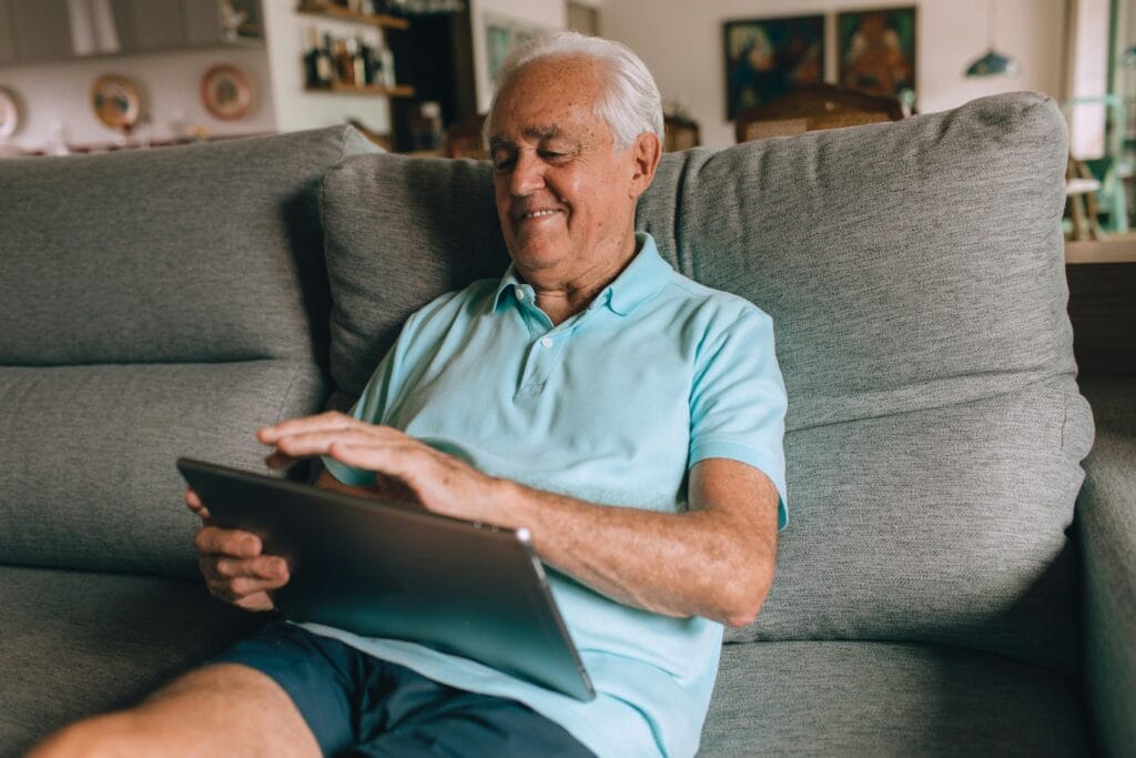 Mann 50+ schreibt eine wertschätzende erste Nachricht auf dem Tablet – Gespräche auf Augenhöhe.