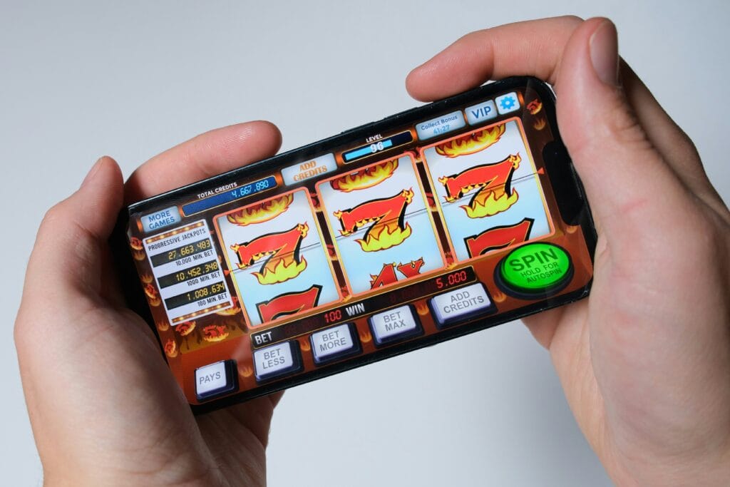 Hand hält ein Smartphone mit virtueller Slotmachine – Symbolbild für Gamification in Dating-Apps