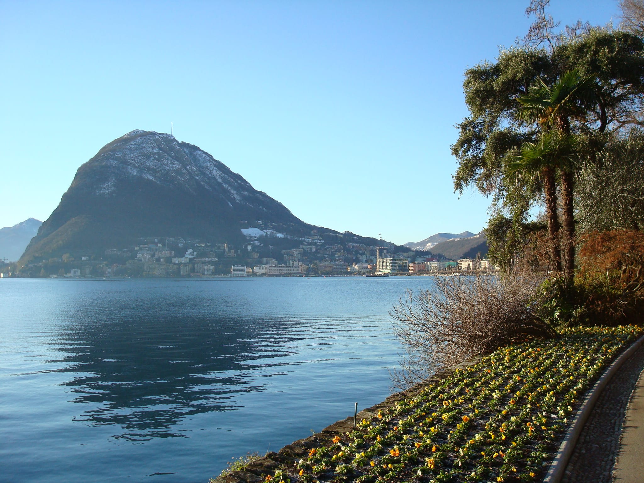 Luganersee mit Uferpromenade und Blick auf Lugano – entspannte Kulisse für Begegnungen ab 50